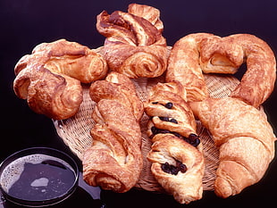 several croissant on brown wicker tray