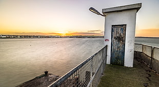photography of white shed near sea during daytime, skerries, dublin, ireland