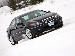 black Acura sedan on snowfield