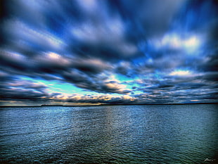 timelapse photography of grey clouds over body of water HD wallpaper
