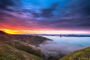 landscape photography of red Golden Gate Bridge near body of mountain during sunset