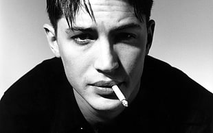 gray scale photo of man wearing black shirt smoking cigarette stick