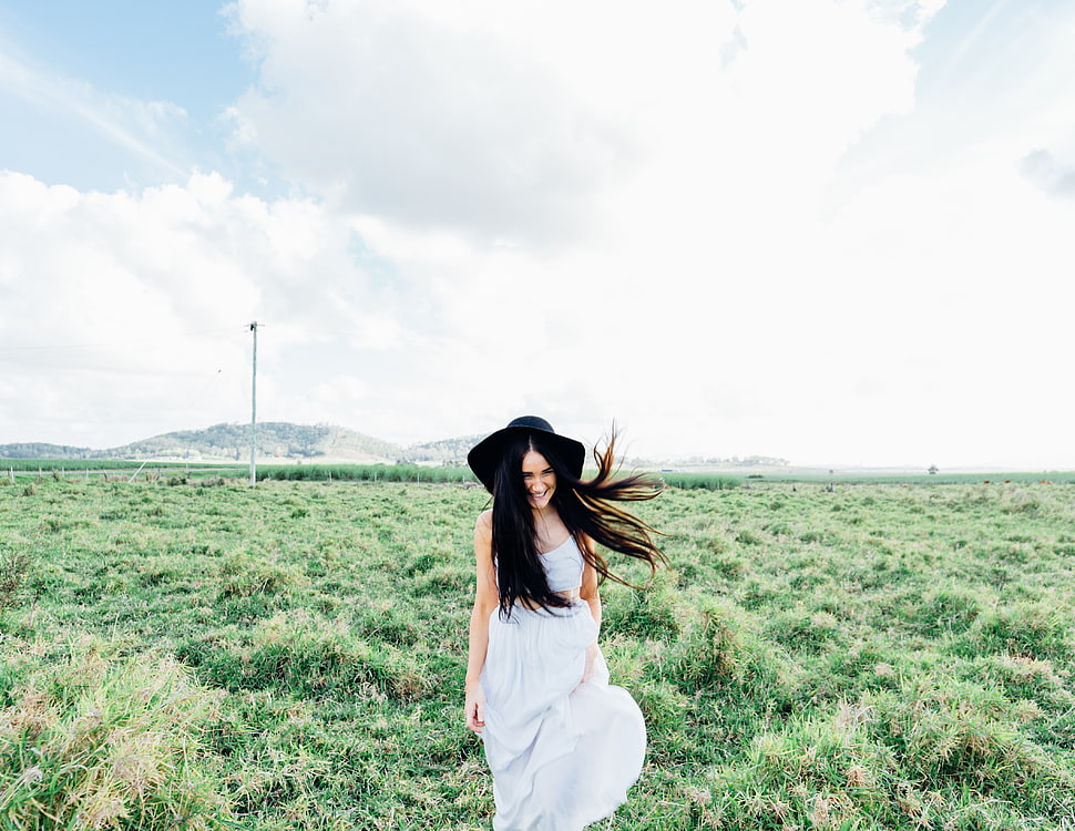woman on white sleeveless dress walking on green grass during daytime HD wallpaper