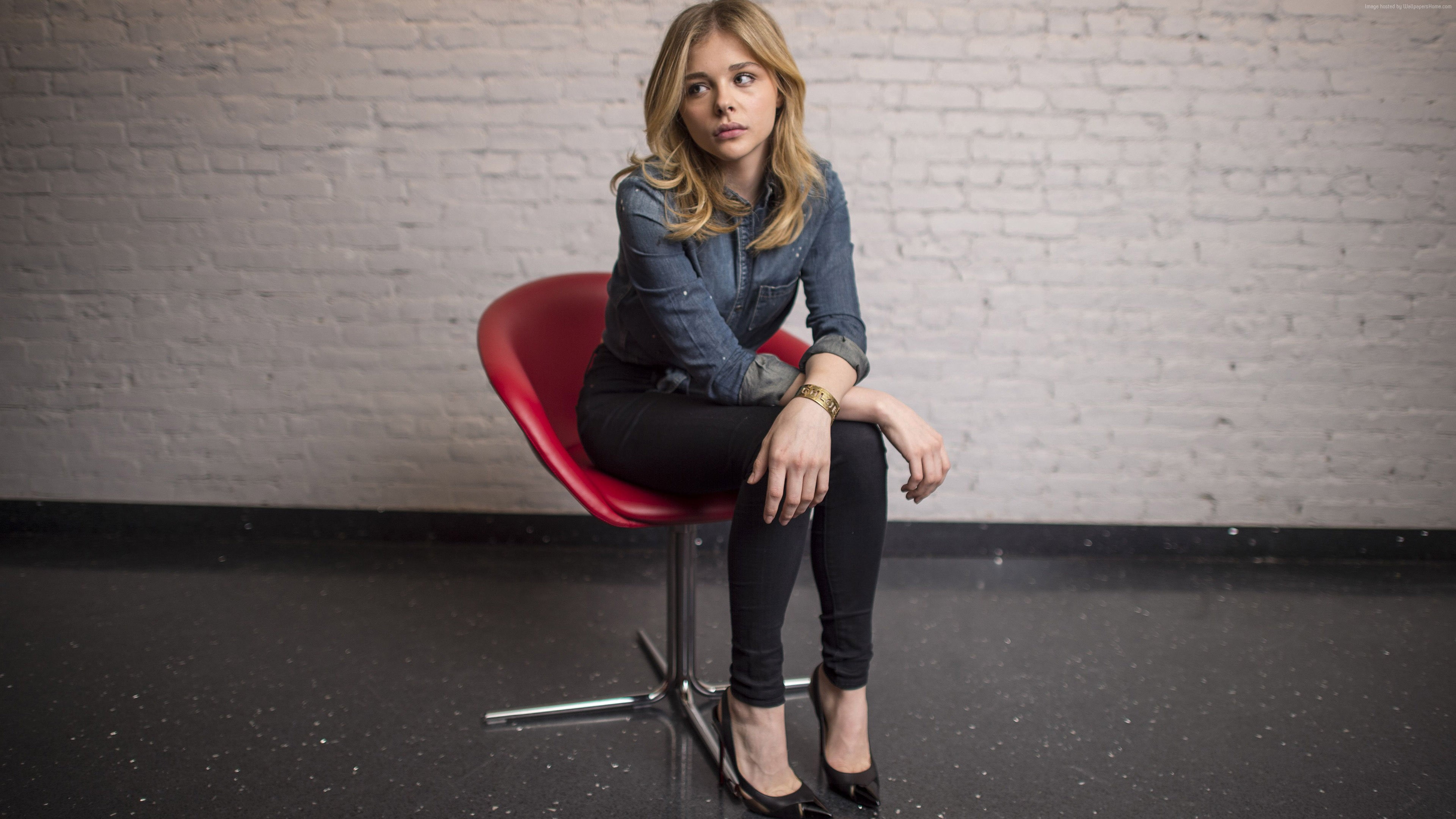 Chloe Grace Moretz sitting on red chair