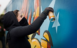 woman painting the wall during daytime
