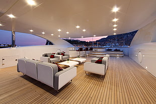 white leather couch set inside yacht with a view of Satorni in Greece