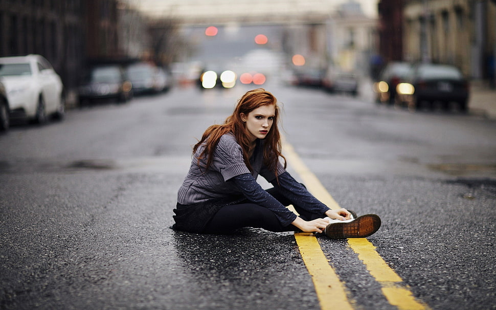 woman in gray sweater and black pants lying on asphalt road HD wallpaper