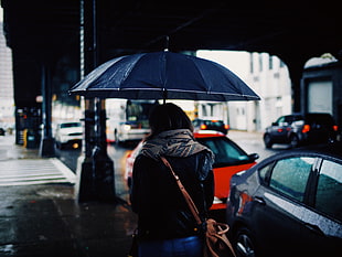 woman holding blue umbrella