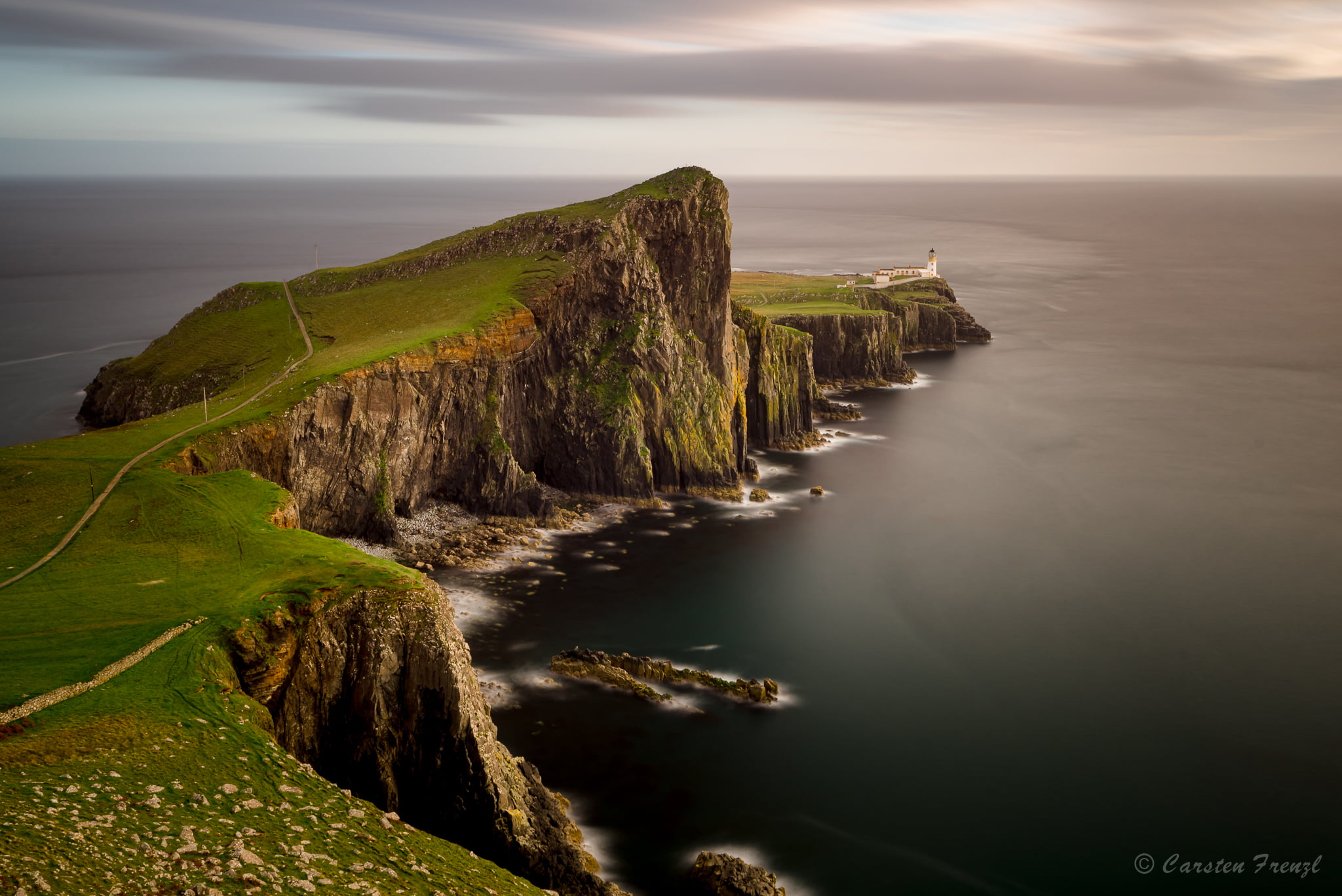 white concrete lighthouse at green land near body of water, neist point