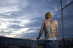 man with back tattoo under white clouds