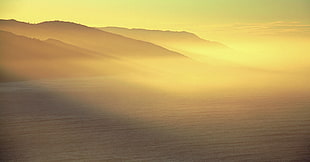 mountain beside ocean during daytime HD wallpaper