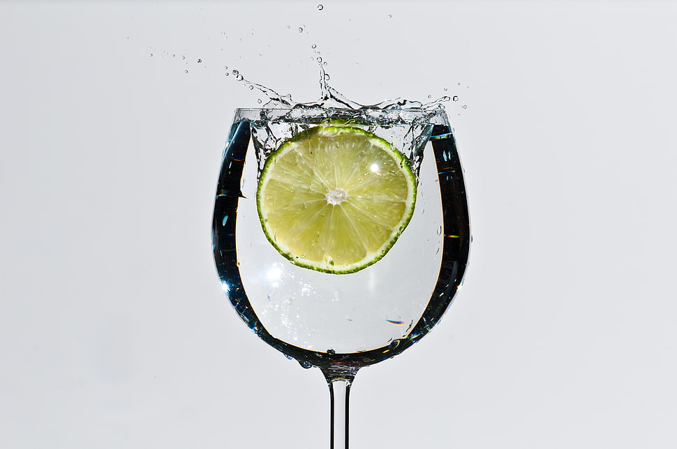 close up photo of sliced lemon splashed in wine glass HD wallpaper