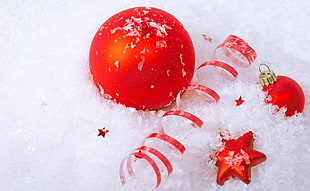 several assorted red Christmas decors on white snow