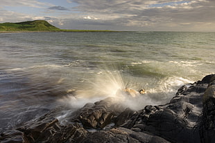 timelapse landscape photography of splash body of water beside rock formation, monreith