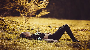 woman lying on grass with her eyes shut and her legs bent HD wallpaper