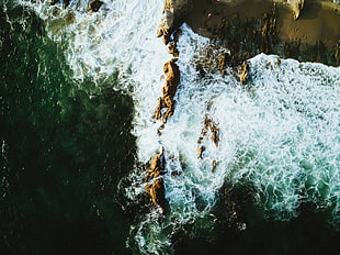 aerial shot of rock formations near shore