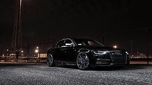black sedan parked on concrete pavement during nighttime HD wallpaper