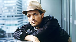 man wearing black long-sleeved top and beige fedora hat inside high rise building HD wallpaper