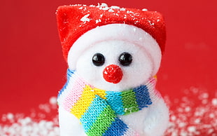 snowman wearing colorful scarf and Santa hat