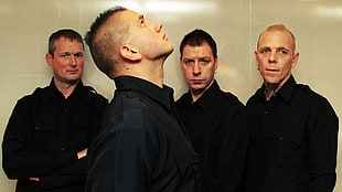 four men wearing black long-sleeved shirts