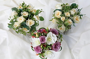 three bouquet of white and purple roses