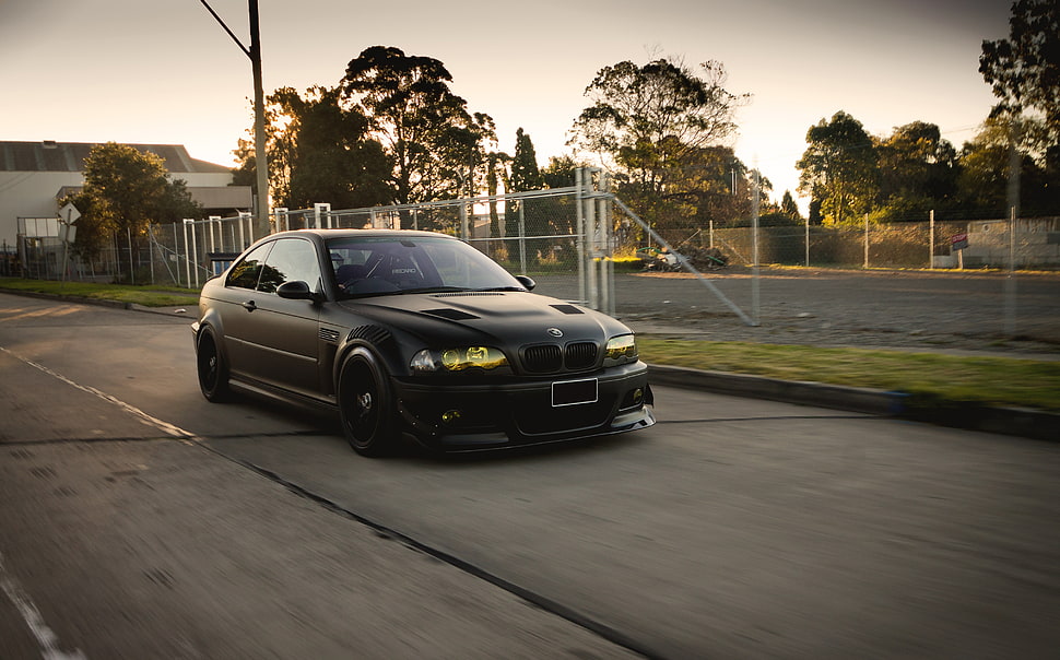 black BMW sedan on concrete road HD wallpaper