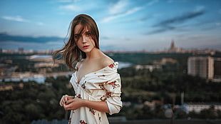 woman wearing white, red, and green floral off-shoulder 3/4-sleeved v-neck dress selective focus photograph