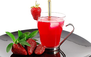 clear glass mug with strawberry beverage and strawberry fruits