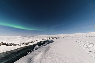 snow-field during daytime with northern lights