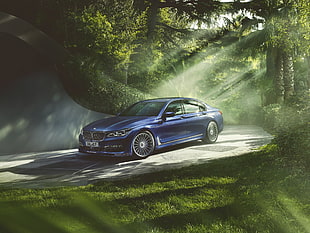 photography of blue BMW M6 sedan surrounded by green leaved trees during daytume