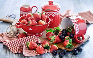 depth of field photography of strawberries on bowl and near cup