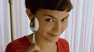 woman with black top holding a spoon
