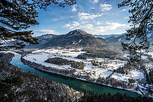 high angle photo of river near mountain range with snow