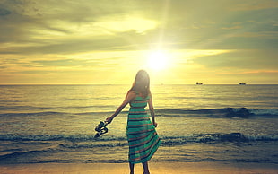 shallow focus photography of woman standing beside beach under sunset HD wallpaper