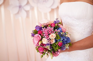 person holding bouquet of pink, white and purple flowers