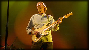 male wearing sunglasses playing guitar