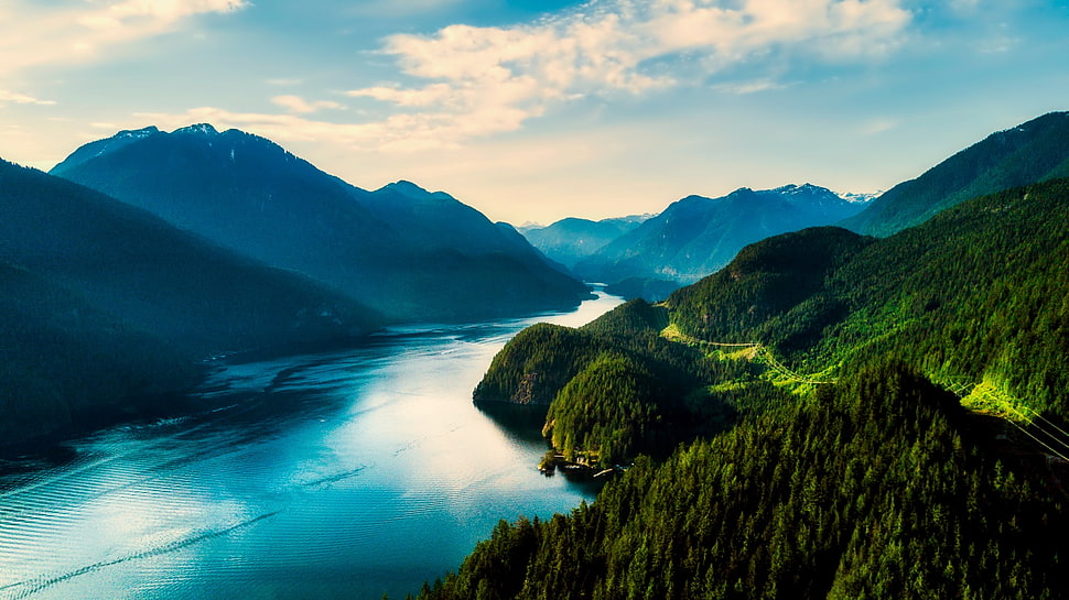 lake in between hills during daytime HD wallpaper