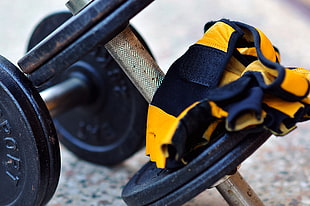 shallow focus photography of yellow and black textile on pair of dumbbell