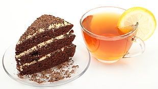 sliced chocolate cake on saucer beside lemon juice