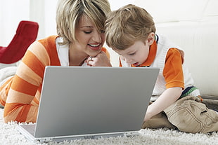 child beside woman near laptop computer