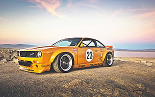 yellow stock car on brown soil under calm sky