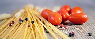 spaghetti pasta, pepper corns, and cherry tomatoes on table