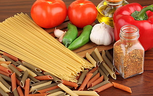 pasta beside tomatoes and seasoning on table