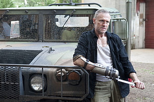 man in black dress shirt sand white tank top standing near car