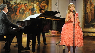 girl wearing pink sleeveless dress in front of black mircophone