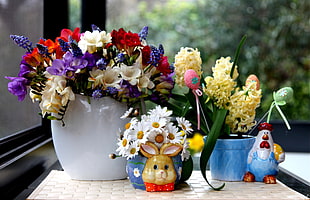 white, red, yellow, and purple flower arrangement int white and blue vases