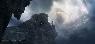 person standing on brown rock, cliff, windy, clouds, canyon