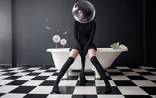 woman in black long-sleeved dress sitting on bathtub