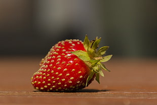 red Strawberry on brown surface in closeup photography HD wallpaper