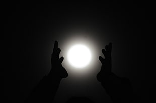 silhouette of human hands under light